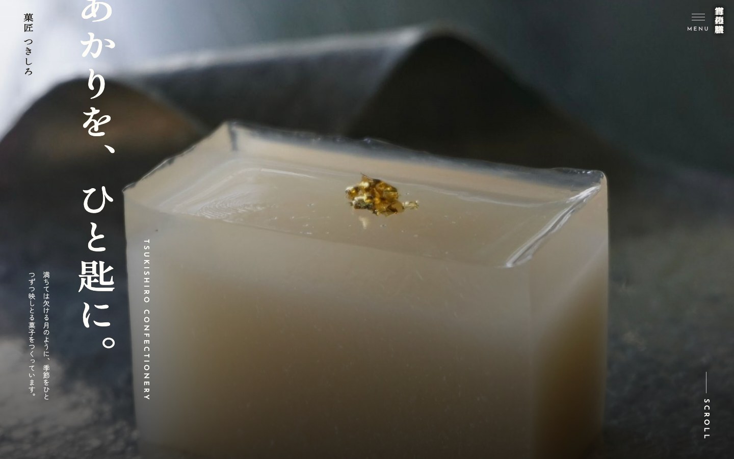 菓匠つきしろのトップページ。金箔をのせた琥珀糖の実写に縦書きの「あかりを、ひと匙に。」。紙色と墨色の和の構成。